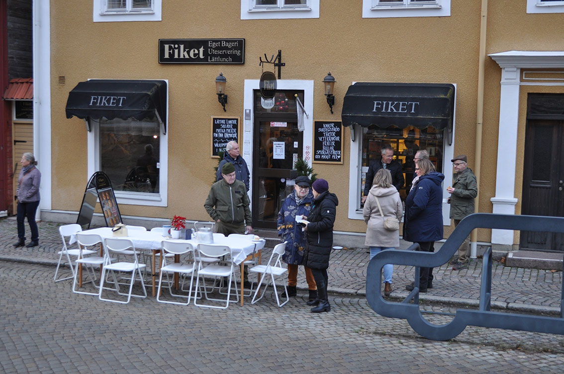 Ett bord står dukat på Brahegatan utanför kafé Fiket i Gränna. Vita plaststolar och en vit pappersduk på fällbordet; en skål med polkagrisar och en julstjärna?