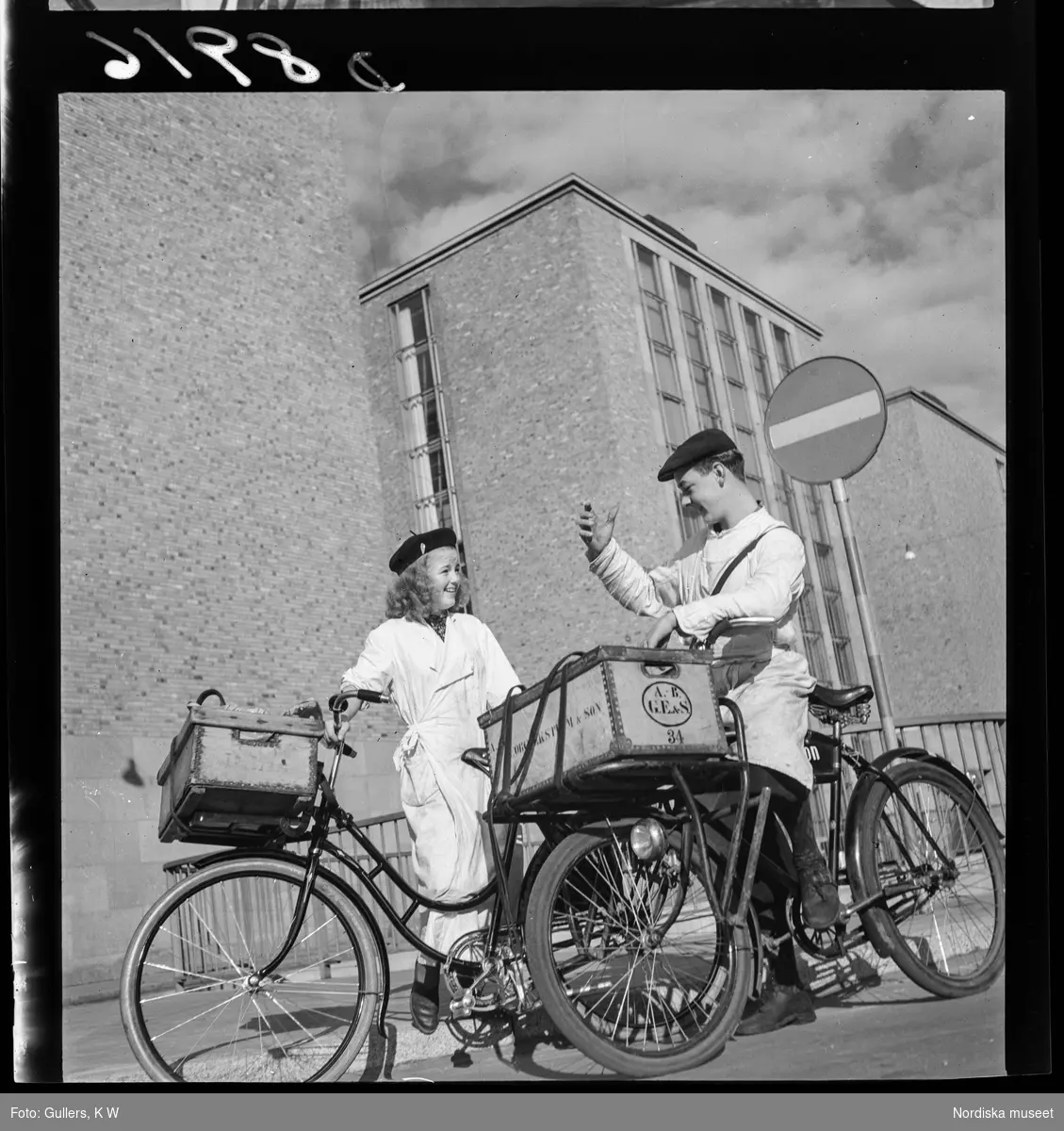 539 Söder. En ung kvinna och en ung man i arbetskläder på cyklar med lådor. På ena lådan syns texten Georg Ekström & Son.