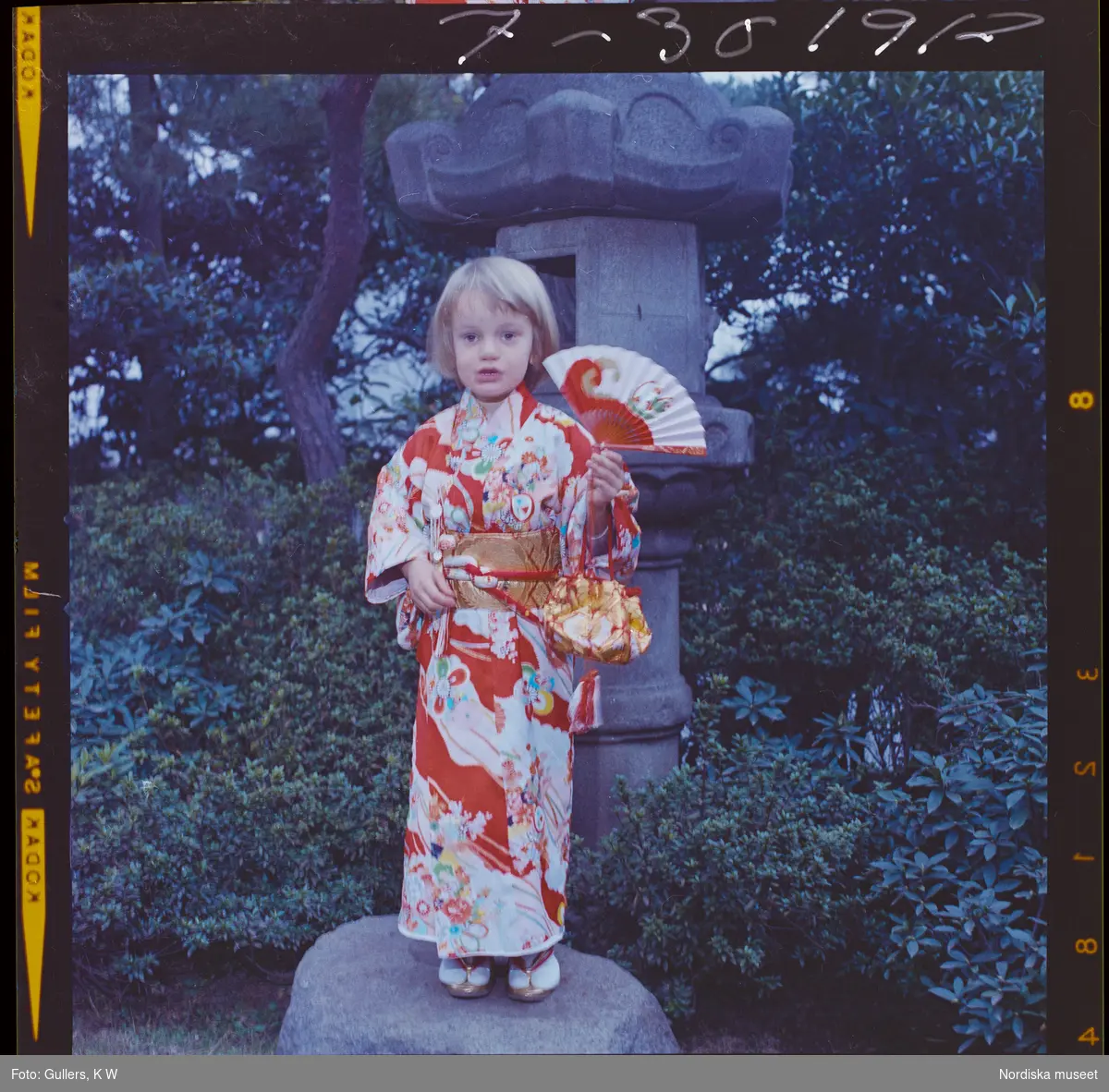 585/8 Facit Tokyo Daberg. Ett barn i kimono står i en trädgård.