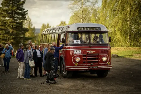 Publikummere som stiger ombord den røde veteranbussen