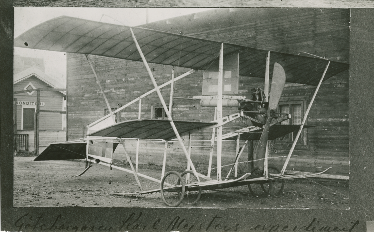 Karl Meisters flygplan Örnen uppställt vid lada, omkring 1914. Avfotografering från monterat foto.