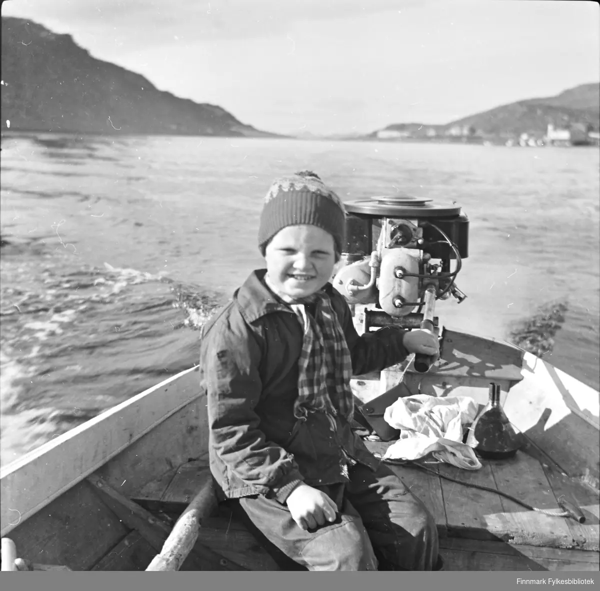 Randi Bjørnstad styrer båten i sundet utenfor Havøysund, 1955.