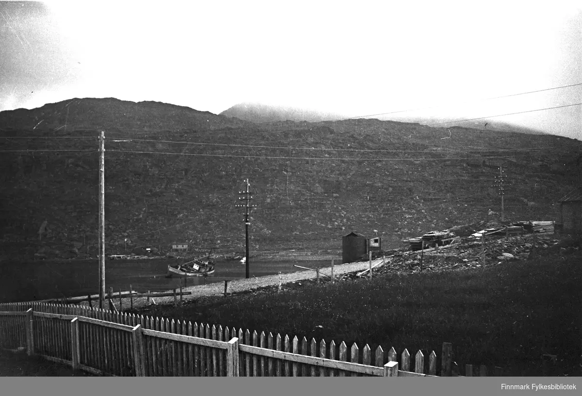 Havarert fiskebåt i sundet i Havøysund tidlig på 1950-tallet. Finnkonefjellet bak.