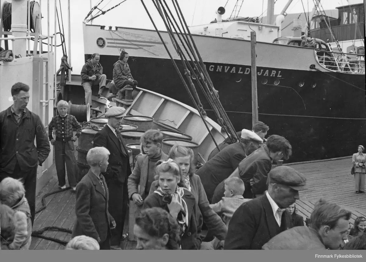 Passasjerer på lokalbåten Sørøy fra Honningsvåg, 1950. Eli og Ingar Bjørnstad sittende bak. Hurtigruta Ragnvald Jarl i bakgrunnen.