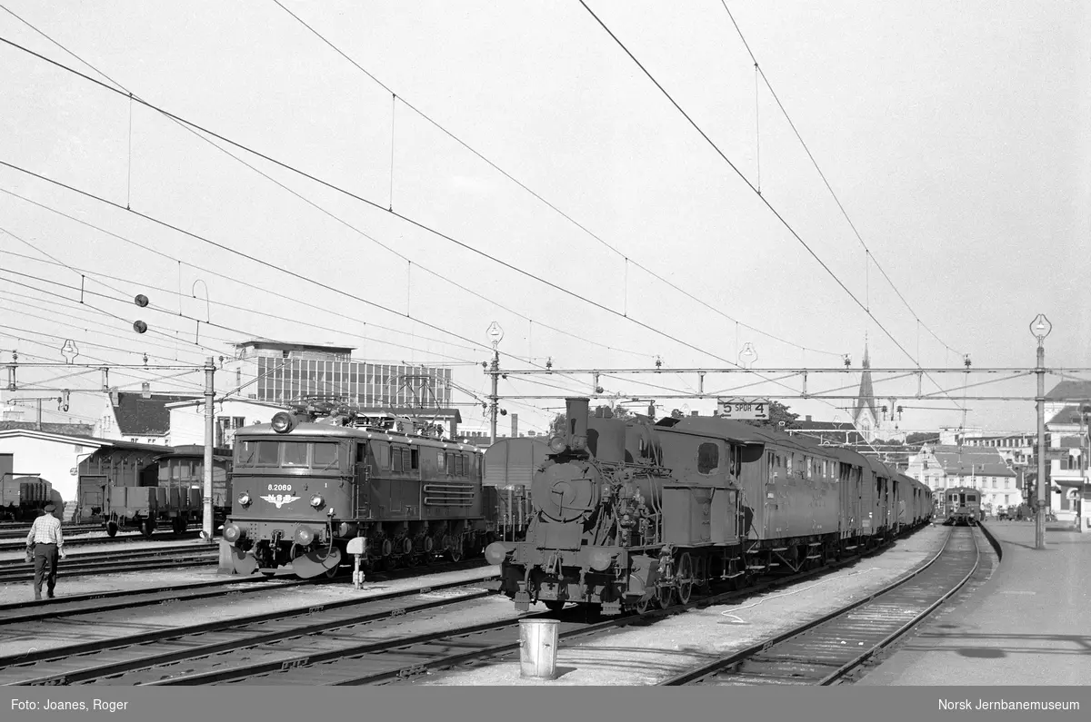 Godstog på Kristiansand stasjon. Til venstre elektrisk lokomotiv type El 8 nr. 2069, til høyre damplok type 25a nr. 238.