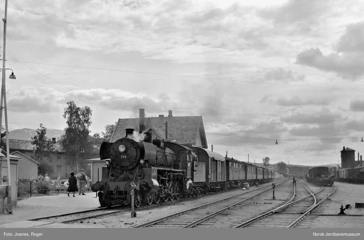 Dagtoget fra Oslo Ø til Trondheim over Røros, tog 301 på Tynset stasjon. Toget trekkes av damplokomotiv type 26c nr. 399.