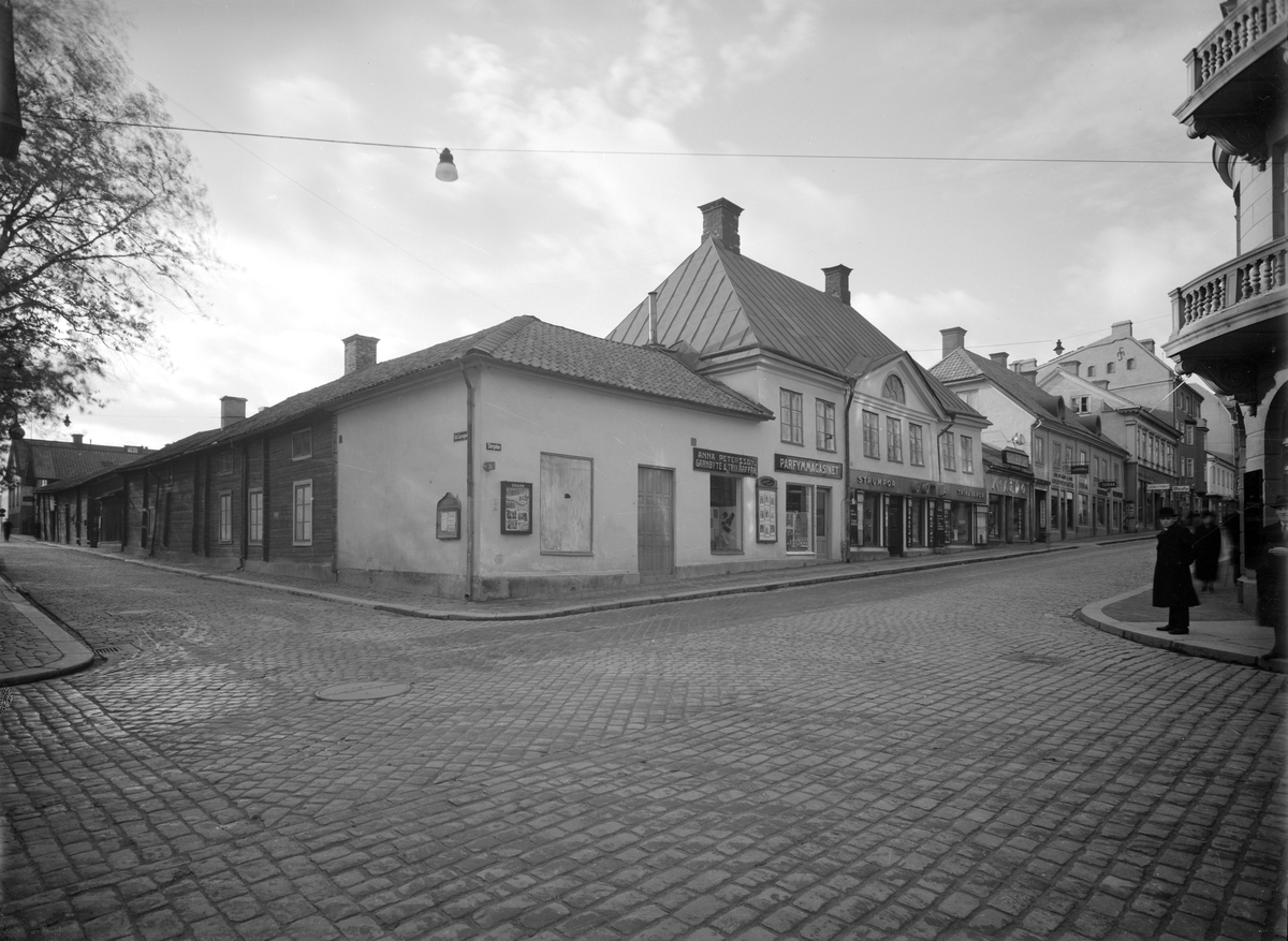 Utblick mot kvarteret Dahlian i Linköping. Vy mot sydväst från korsningen av Storgatan och Sankt Larsgatan. Tornbergska gården, i blickfånget, kom att flyttas till friluftsmuseet Gamla Linköping 1961. Markörer i bilden daterar exponeringen till 1936.