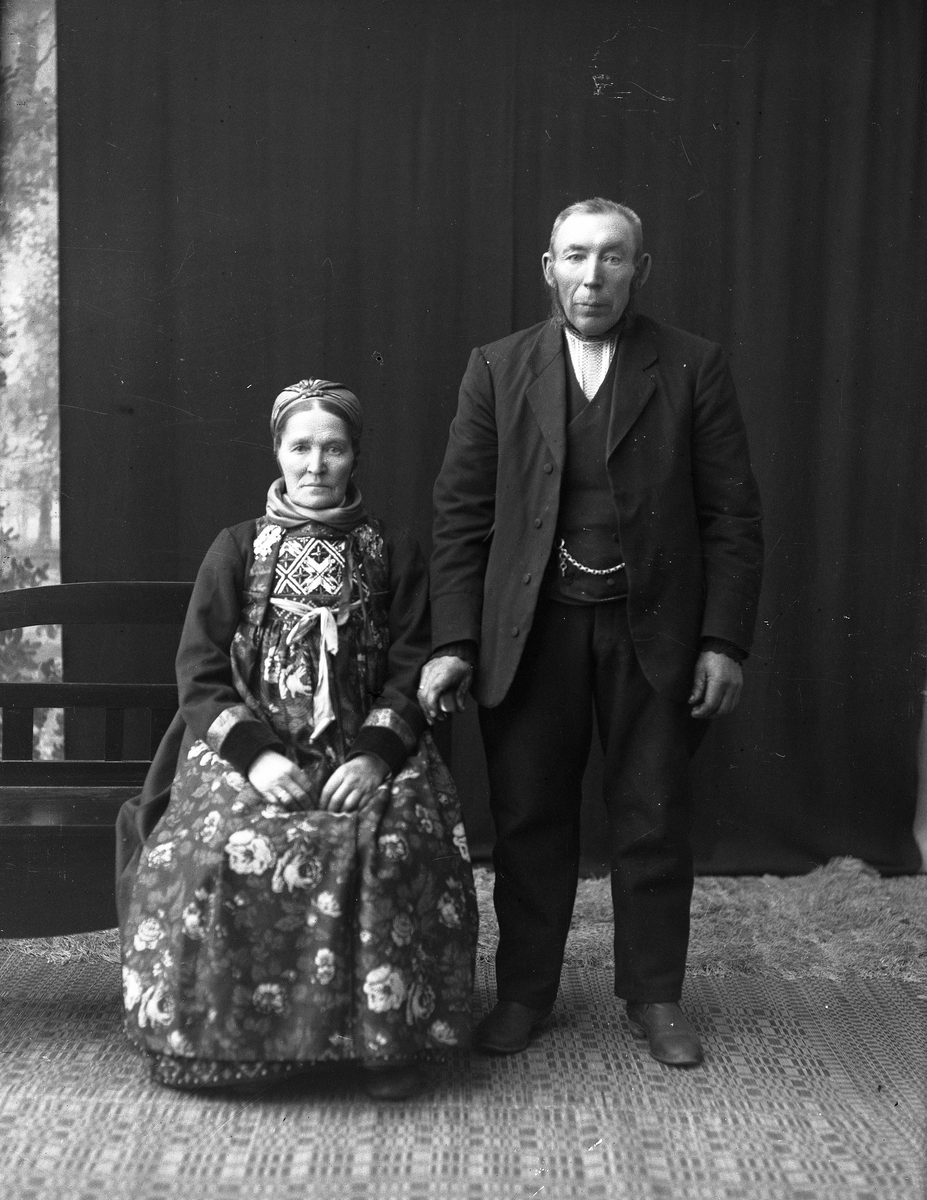 Portrett av kvinne med bunad og mann med dress.