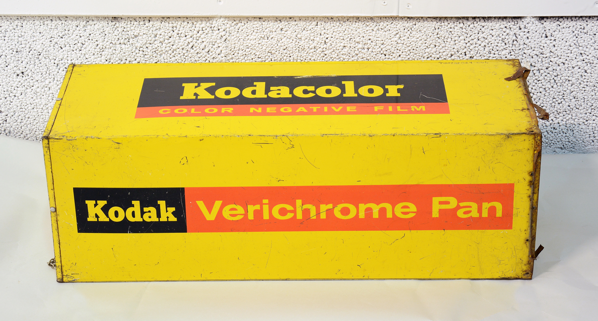 Reklame for Kodak, formet som en stor filmboks i metall med oppheng, til å henge opp på utsiden av fotobutikken.