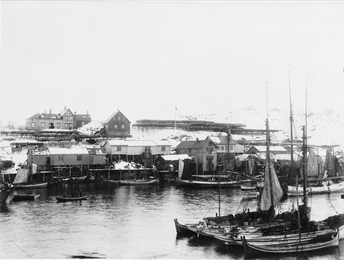 Fiskebåter i havn i Sørvågen i Lofoten. Bygninger og fiskehjeller i bakgunnen.