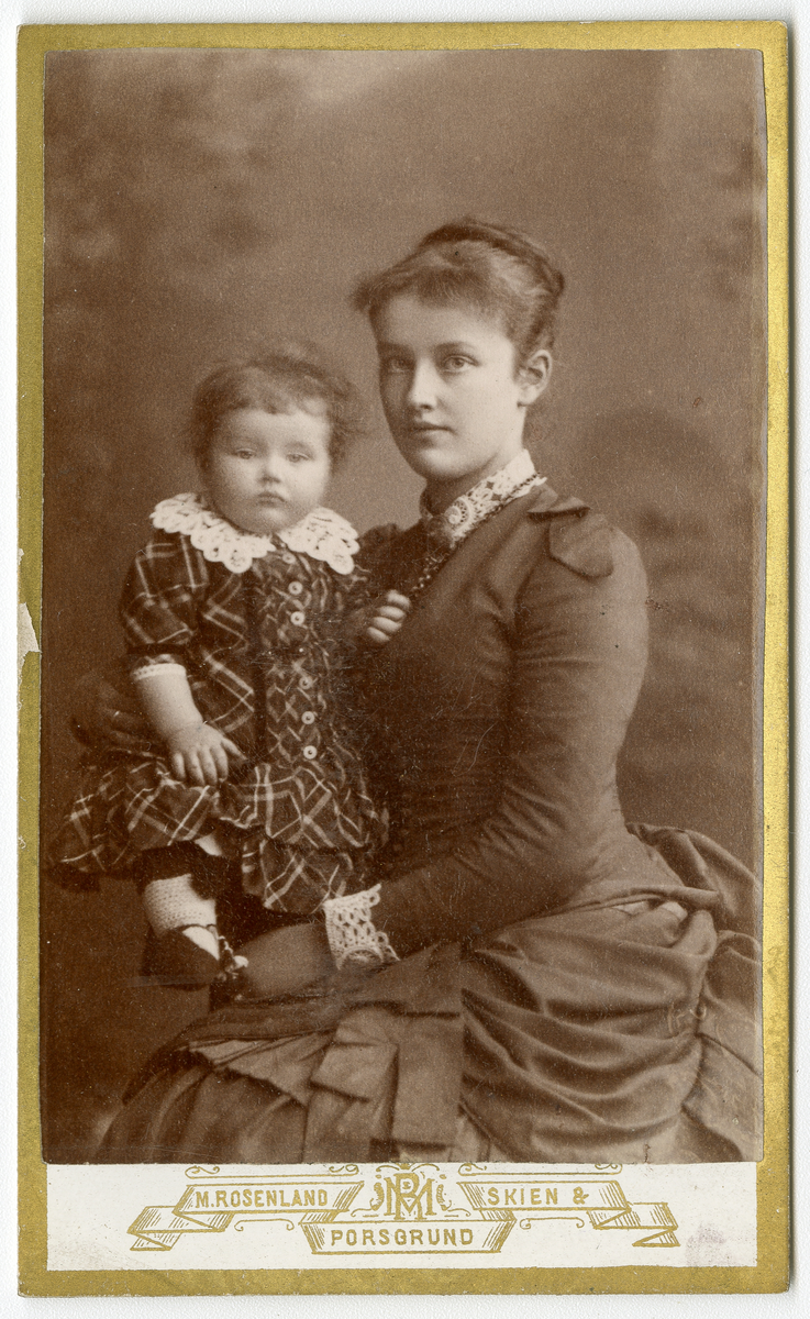 Portrettfoto av kvinne med barn. 

Trolig Nicoline Aall gift Torstensen (1862 - 1941) sammen med et av sine barn, trolig Charlotte Aall (f.1885)

Elisabeth arbeidet som lærer i stenografi i 1910