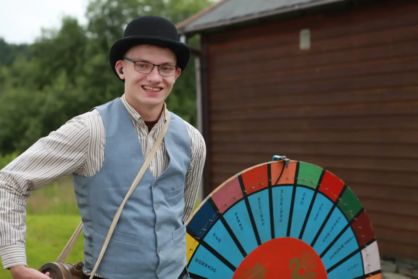 Sommervert med vest og bowlerhatt ved lykkehjul