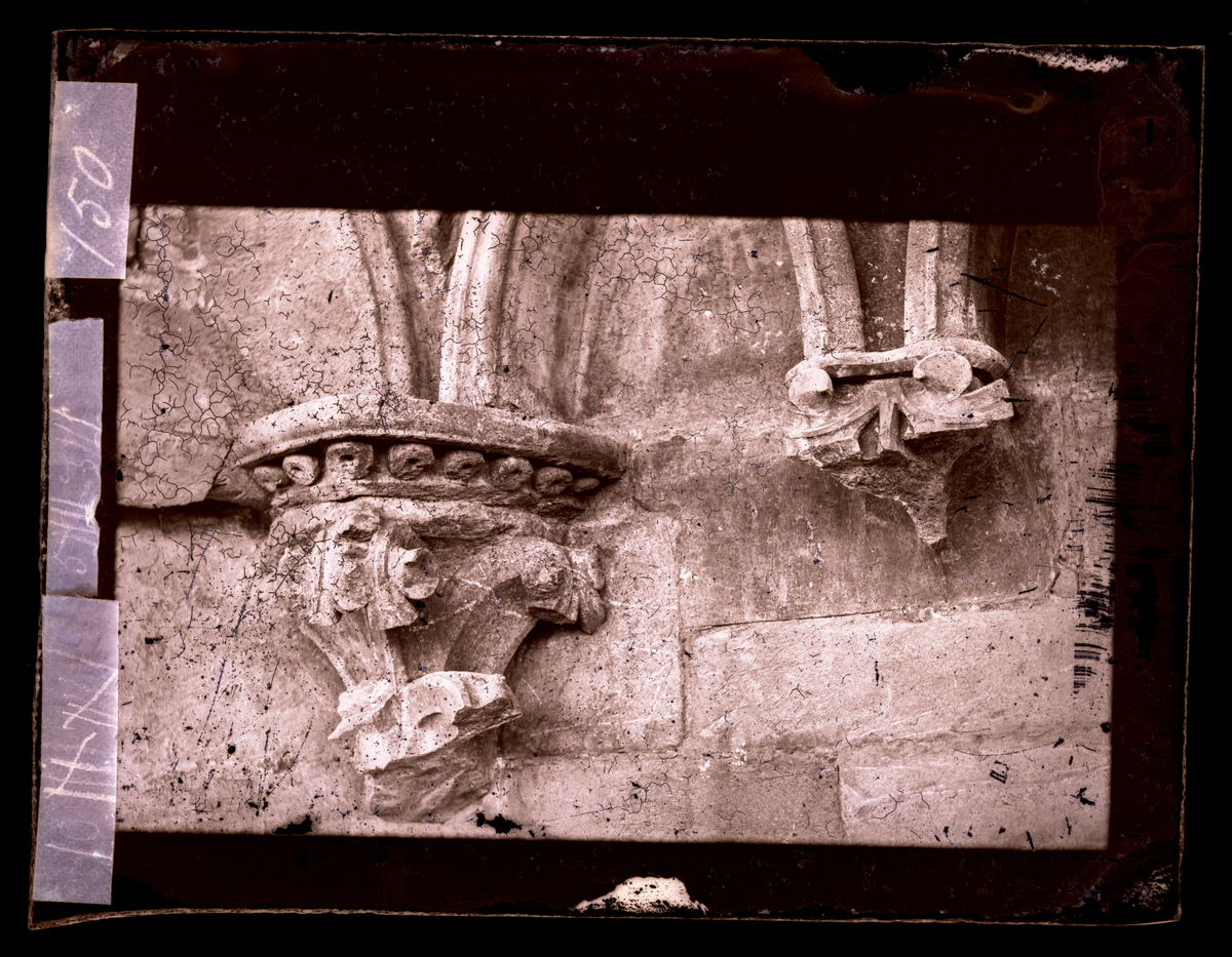 Konsollfigur fra buefrisgesims på nord-østre side av oktogonen i Nidarosdomen. Konsollfiguren til høyre i bildet er skadet, men har vært dekorert med bladverk. Til venstre et bladverkskapitel.