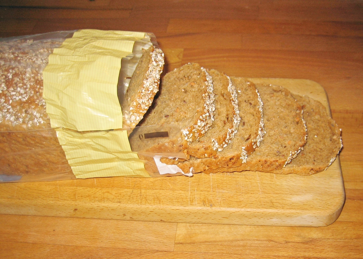 På brødposens forside er et motiv med et fargefotografi av flere liggende kornaks. På posen bakside er et fargefotografi av tre brød og en bunke med brødskiver. Det ene brødet er stablet opp på to brød. I bakgrunnen skimtes to brød i et brødstativ og en stålbenholder med mel.