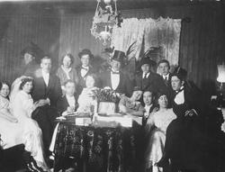 Bryllupsgjester samlet rundt et bord sammen med brudeparet