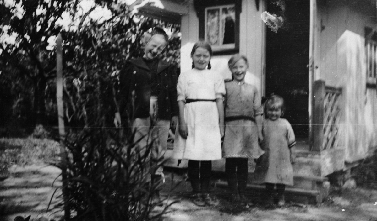 Fire barn utenfor et dukkehus.