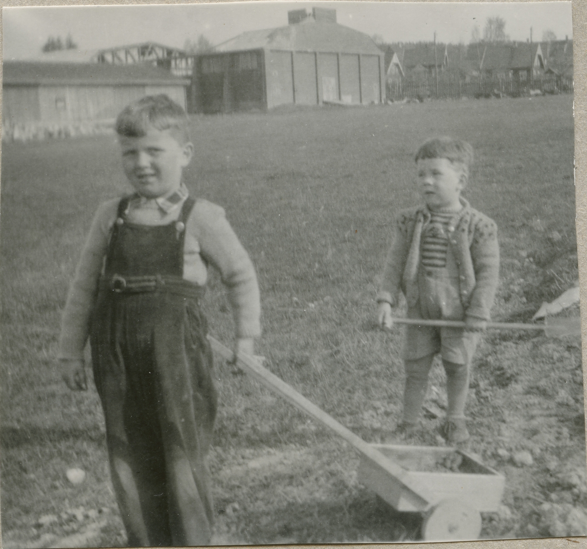 To små gutter leker med spade og vogn på Laakejordet-