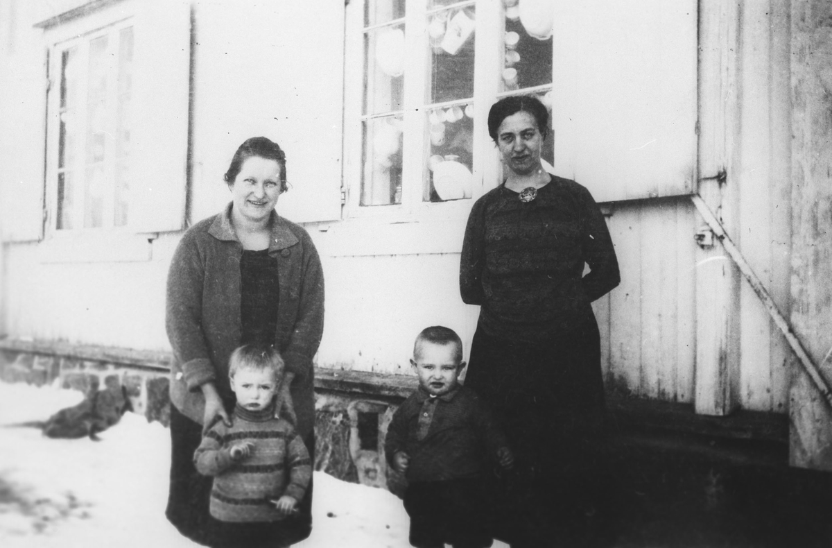 To kvinner med to barn foran den gamle butikken på Nardu Rolstad m/postkontor.