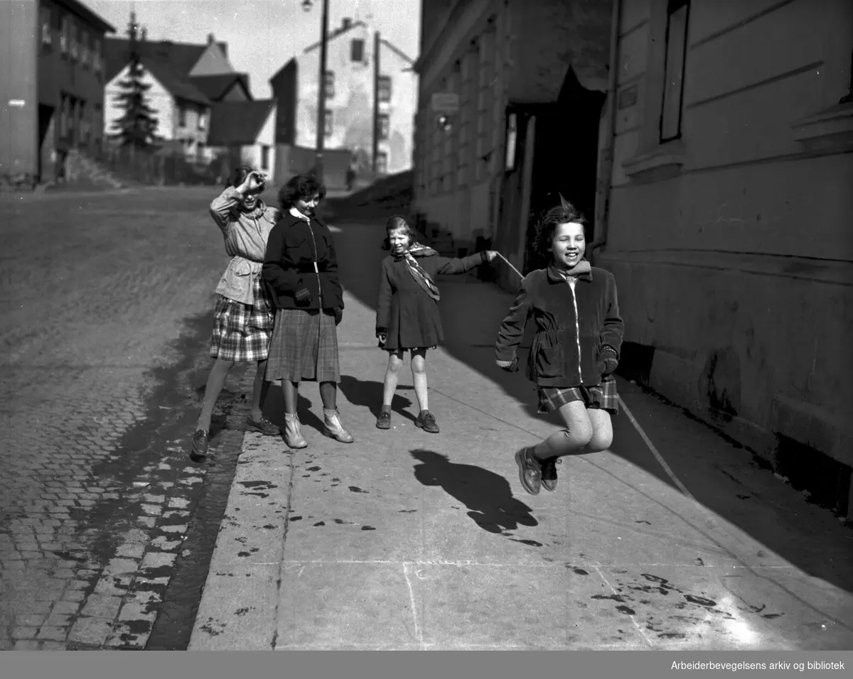 Jenter hopper tau på fortau,.mars 1953.