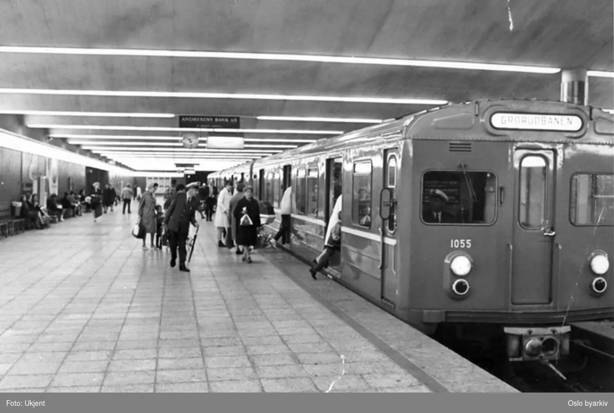 Oslo Sporveier. T-banevogn 1055, serie T1, i tog på linje 5, Grorudbanen, her på Jernbanetorget T-banestasjon. Påstigende reisende. (Banen forlenget fra Grorud til Rommen og Stovner 1974, til Vestli 1975.) Bildet tatt en gang mellom 1970-1977.