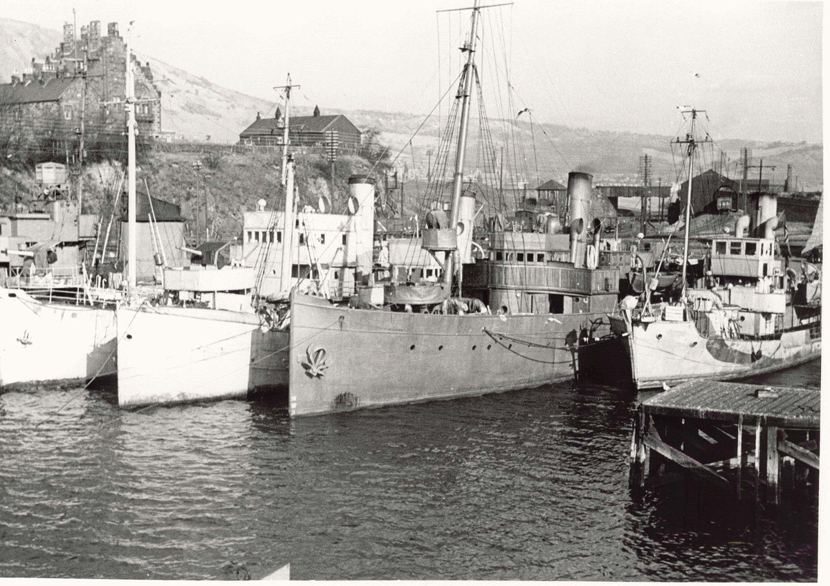 Motiv: Marinefartøy i opplag i Burntisland 1944.Babord baug.Fra venstre :Jageren Sleipner, Minesveiperen Thorodd, Minesveiperen Alcmaria, Kommandofartøyet Heimdal, Minesveiperen Bjerk