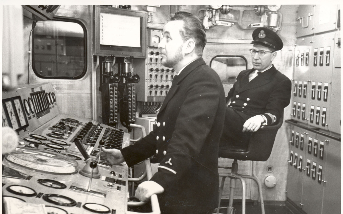 Tjueen foto fra fregatten KNM "Oslo" under tjeneste vinteren 1967 i Nord-Norge. Livet om bord. Maskinist Kvm.II.kl. Bjørn Midtsund og maskinmester B. Vollen i maskin kontrollrom