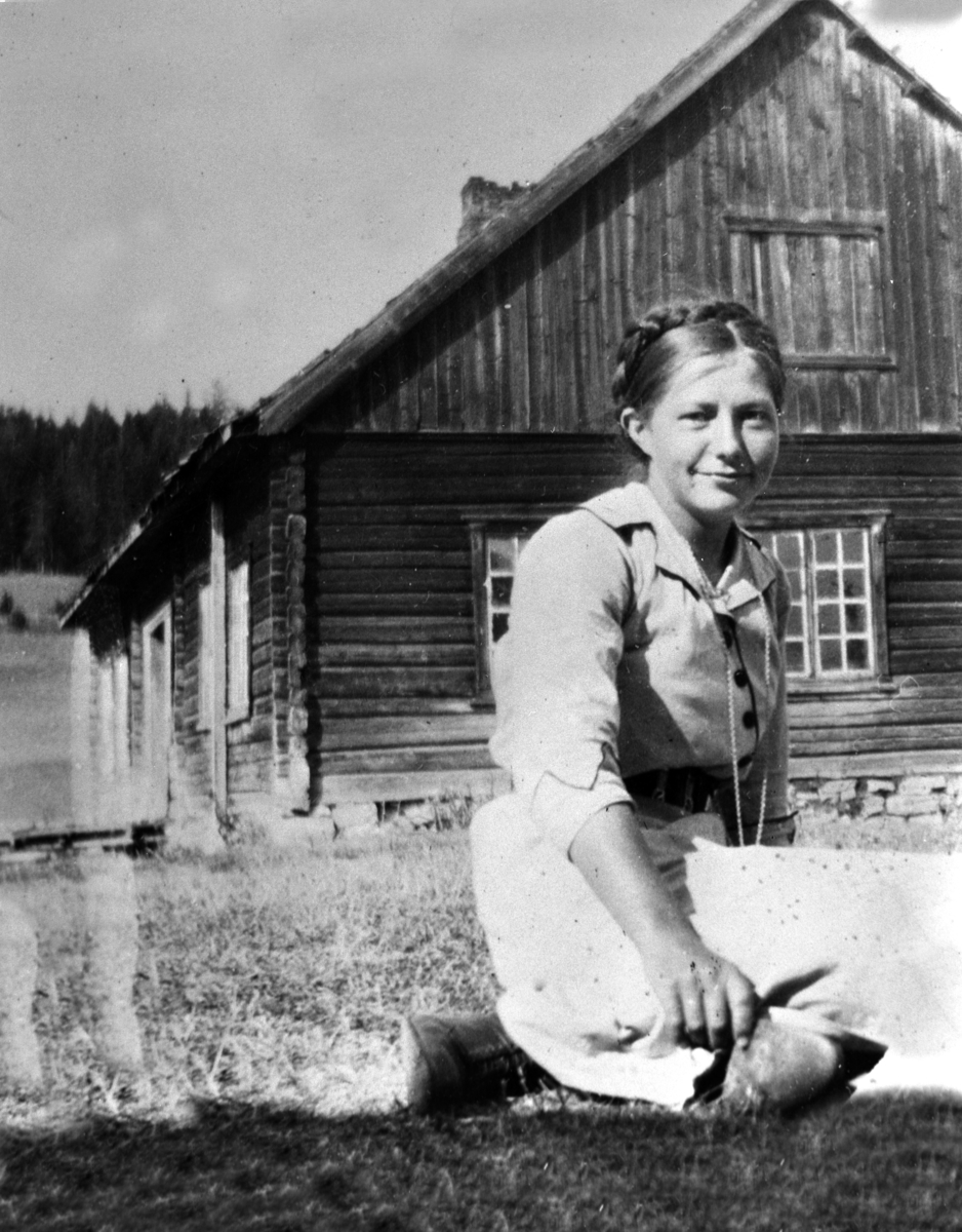 Karen Maurud f.1895 sitter foran hovedbygningen på Øvre Maurud (Oppstabygningen), Helgøya.