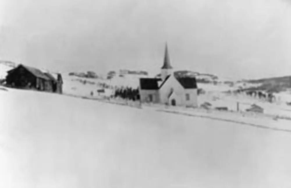 Brøttum kirke sett utvendig i vinterlandskap.