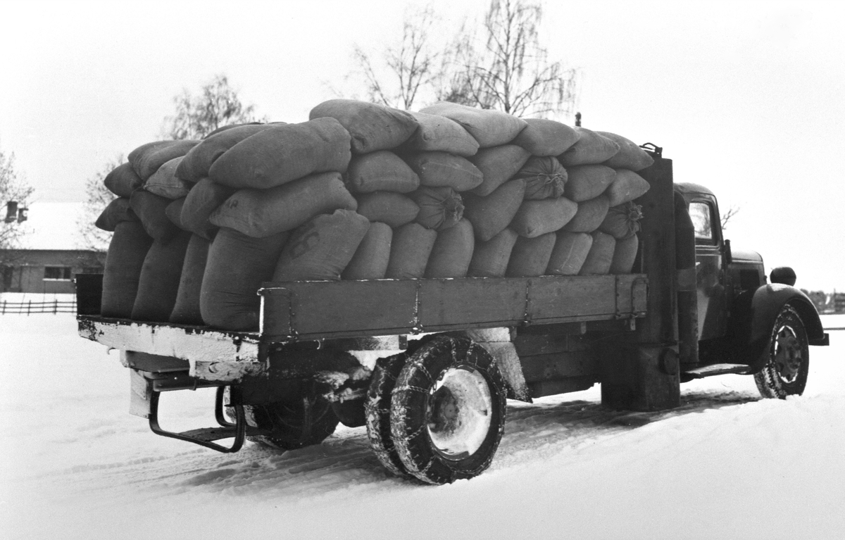 Lastebil med knottgenerator på siden. Transport av kornsekker til Strand Brænderi, Moelv, Ringsaker.