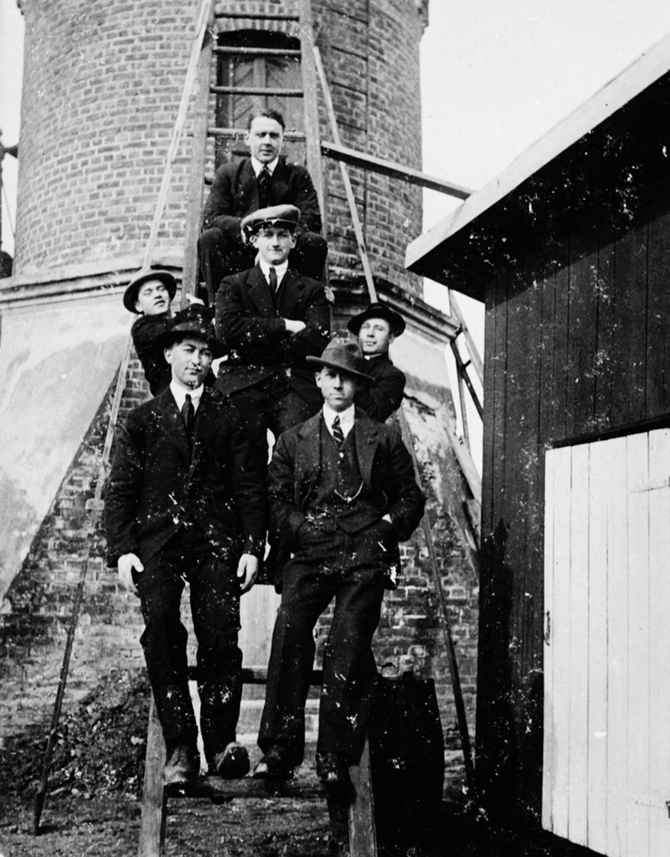 Seks unge menn i trappa til vanntårnet på Brumunddal stasjon. Bak Wilberg, Birger Bækkevold, Harald Hansen, Marthinus Larsen, Marthinus Olsen, Hans Holter.