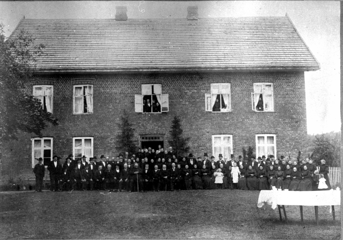 Stor gruppe mennesker samlet foran hovedbygningen på Kise mellom, Nes, Hedmark ved begravelsen etter Marie Gjestvang f. Heramb (1853-1907) .