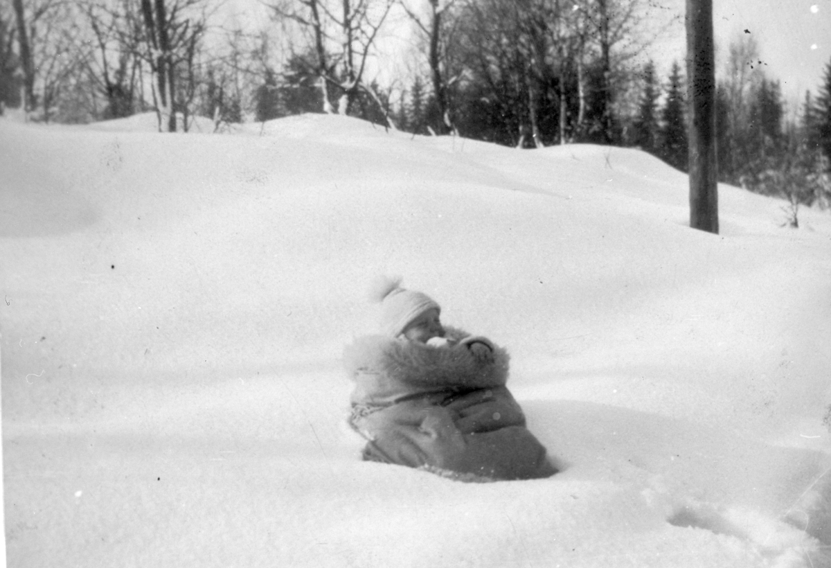 Barn, ukjent, fotografert i sauskinnspose ute i snøen. 