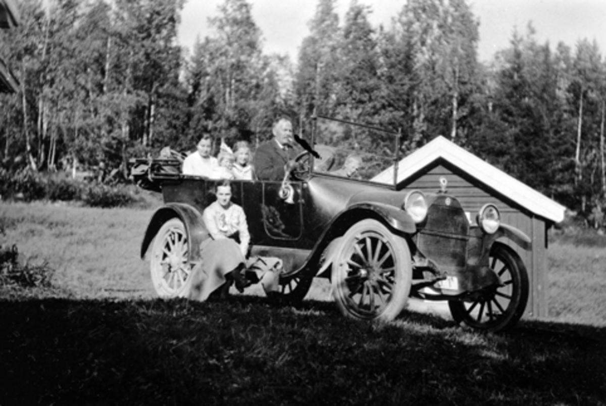 Ole Hougsrud bak rattet på sin Studebaker ca 1916 mod. med reg.nr D-1, på Hov, Tangen. Renten av folkene er ukjente.