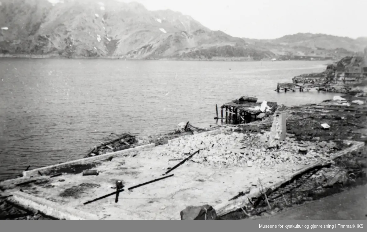 Honningsvåg 1945. Rester av kullkaia og en murt boligflate i forgrunnen.