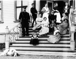 Amtmann Graff med familie, hushjelper og hund på trappa til 