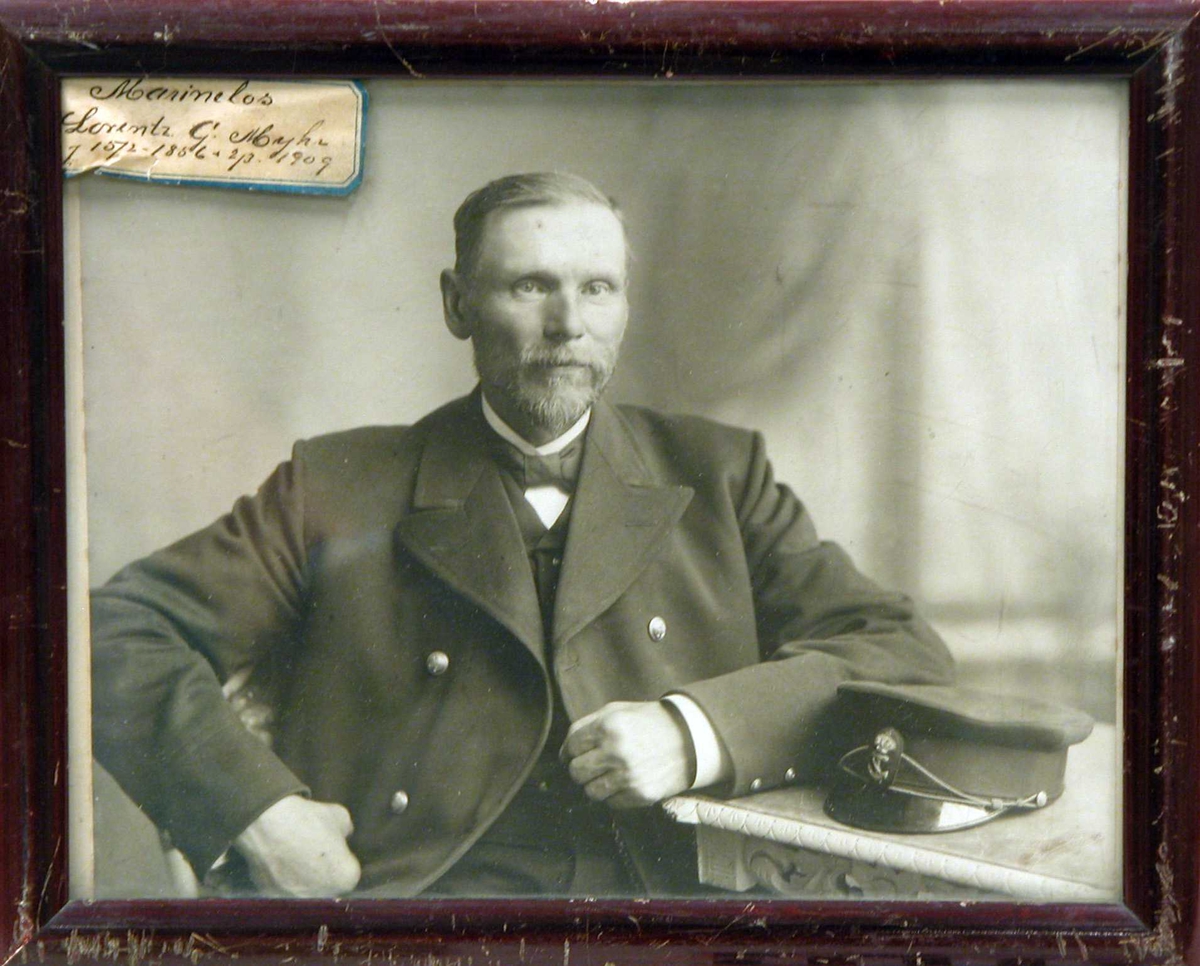 S/h portrettfotografi av marinelos Lorentz G. Myhr sittende ved et bord.