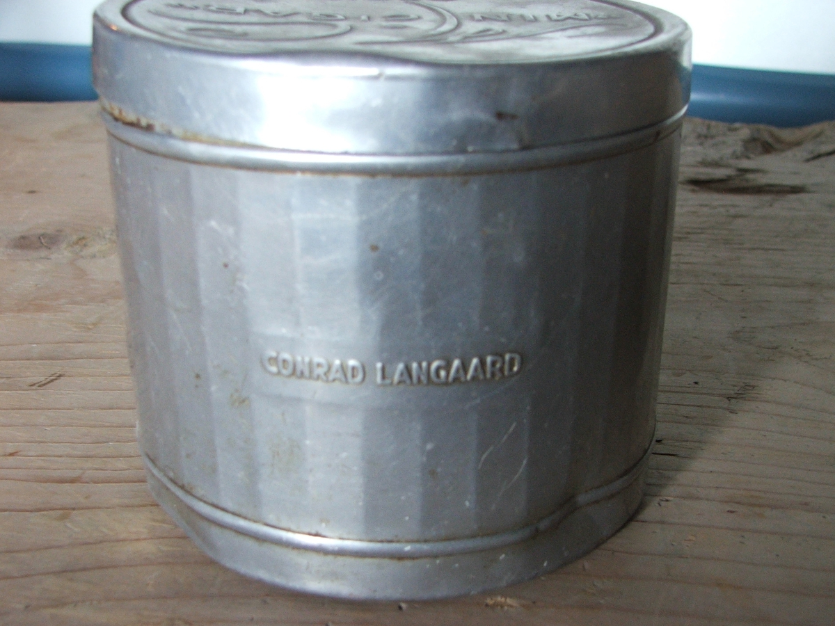 En rund boks i metall med lokk