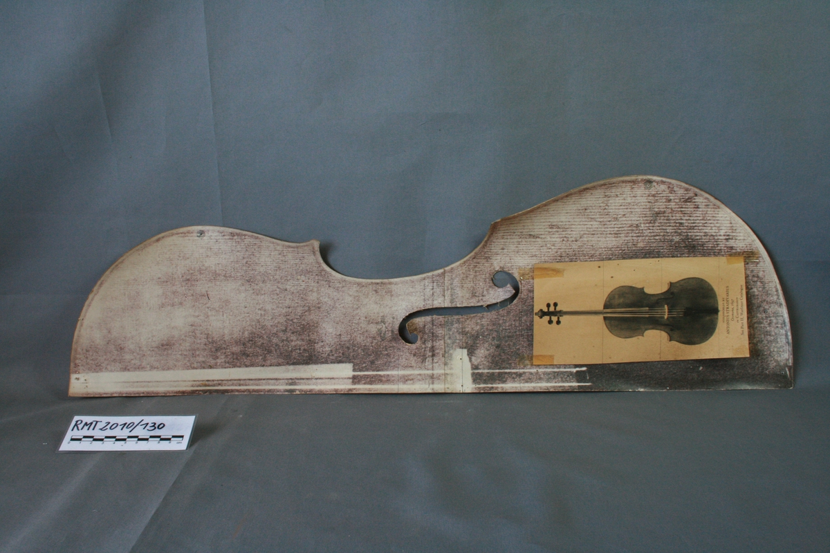 Papir. Forestiller en halv cello, med påklistret bilde av cello Stradivari 1697.