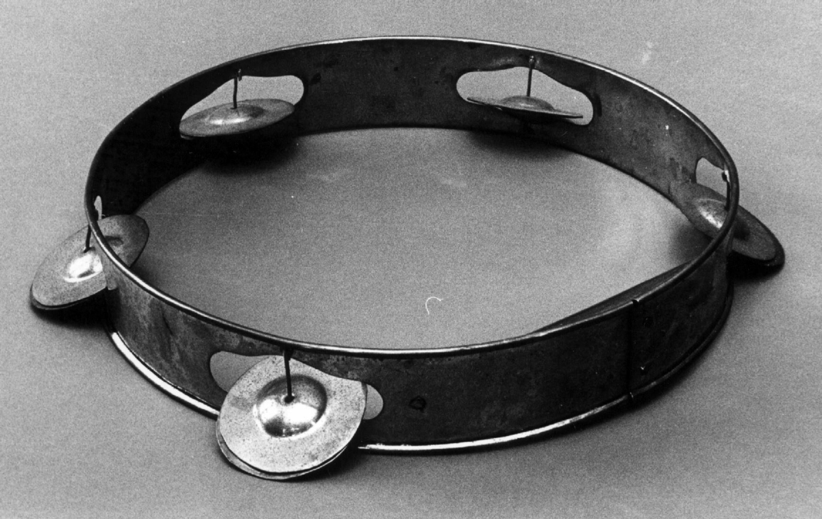 Messingring med fem cymbaler festet med metall-streng i åpninger i ringen.

