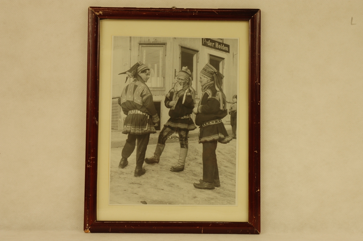 Tre menn i nordsamisk kofte og en gutt foran Peder Holdens forretning i Kjerkgate på Røros.