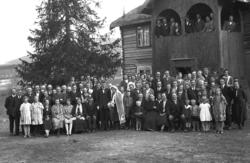 Bryllupsgjester, fin veranda på huset bakom.