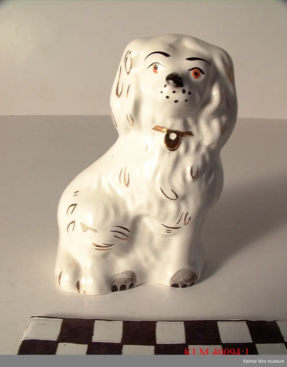 KLM 40094:1 Figur, porslin. Föreställer en hund, vit med detaljer i guldfärg. Stämpel: Beswick, England 1373.
