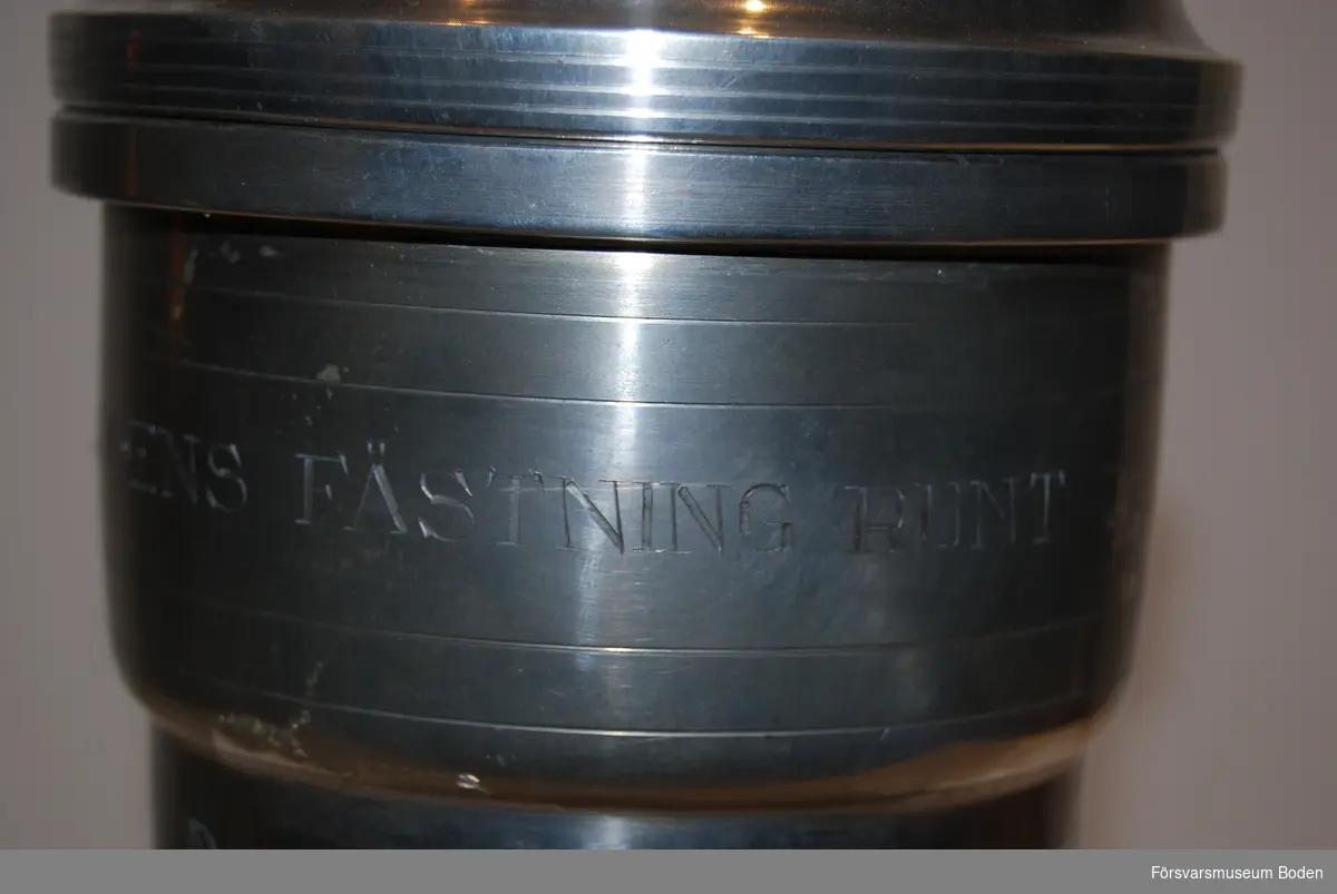 Pokal av tenn på fot av svartlackerat trä. Med avtagbart lock. Pokalen har tre lags inskriptioner: A 5 /S 1B 1945, A 5 1947 och A 5 1948.