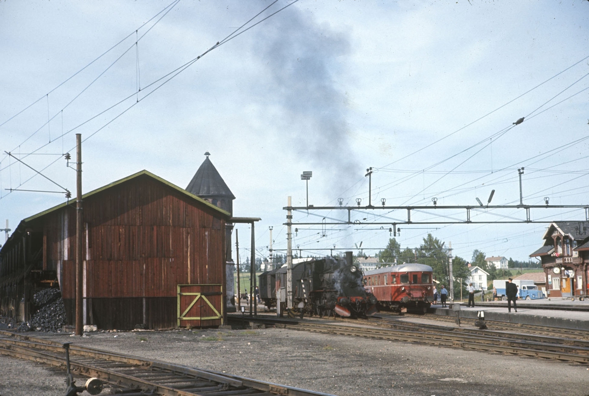 Damplokomotiv type 27a nr. 296 med godstog fra Skreiabanen på Eina stasjon. Til høyre persontog til Gjøvik