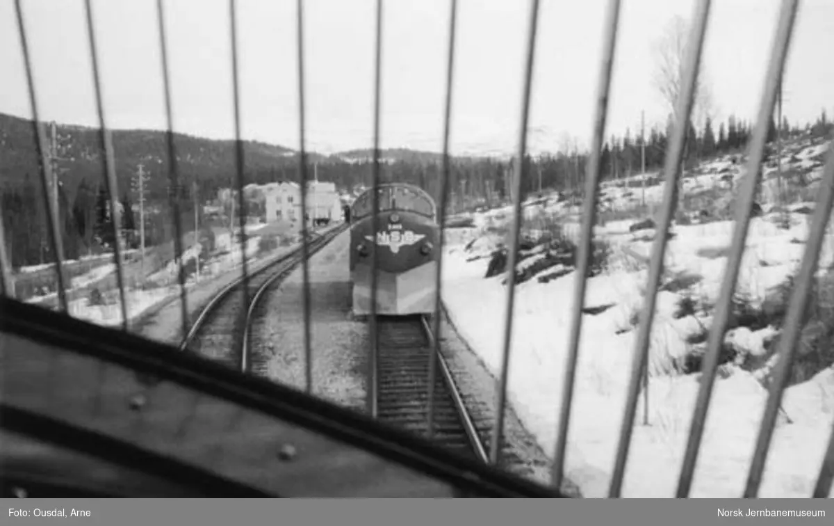 Kryssing på Namsskogan stasjon sett fra førerplassen i et diesellokomotiv. Diesellokomotiv Di 3 605 venter med motgående tog.