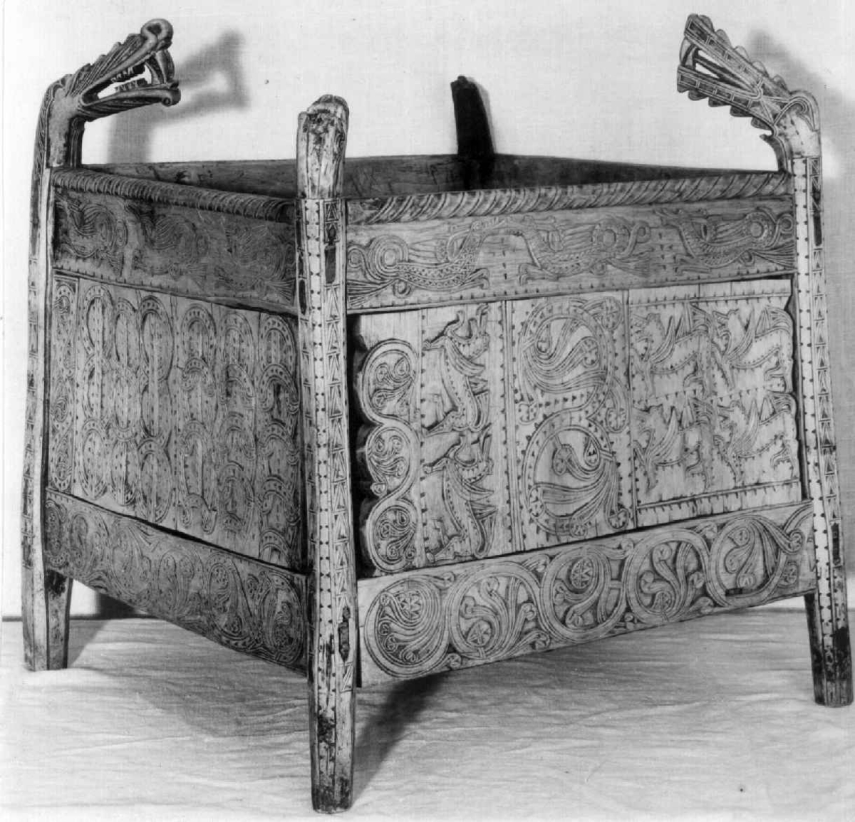 Fire søyler med skåret dyrehode-ornamentikk, sammenføyet med tverrbord og fyllinger. Bunn er åpen foruten to tverrstaver. Hele utsiden er rikt dekorert med utskåret dyr og ranker.