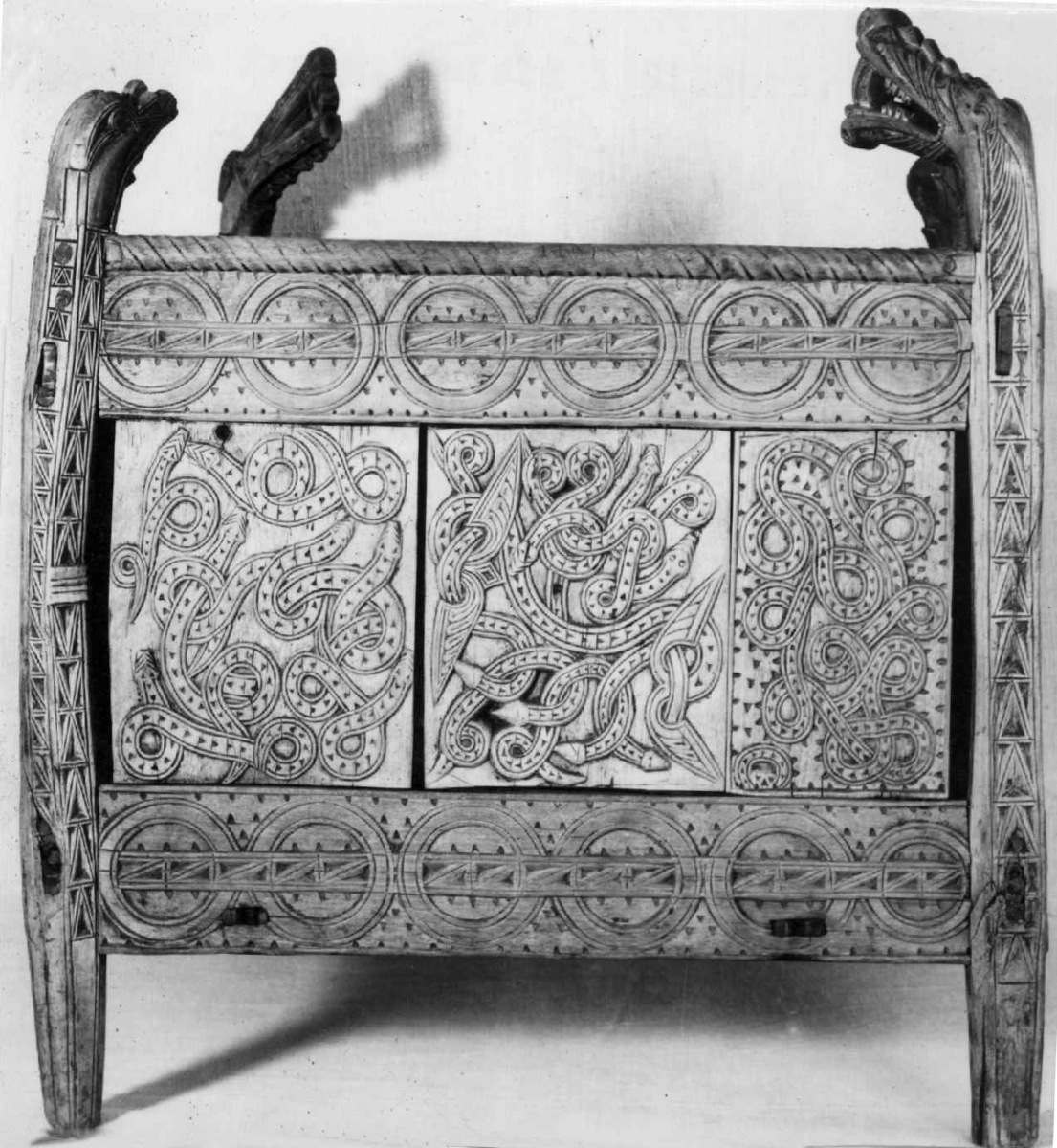 Fire søyler med skåret dyrehode-ornamentikk, sammenføyet med tverrbord og fyllinger. Bunn er åpen foruten to tverrstaver. Hele utsiden er rikt dekorert med utskåret dyr og ranker.
