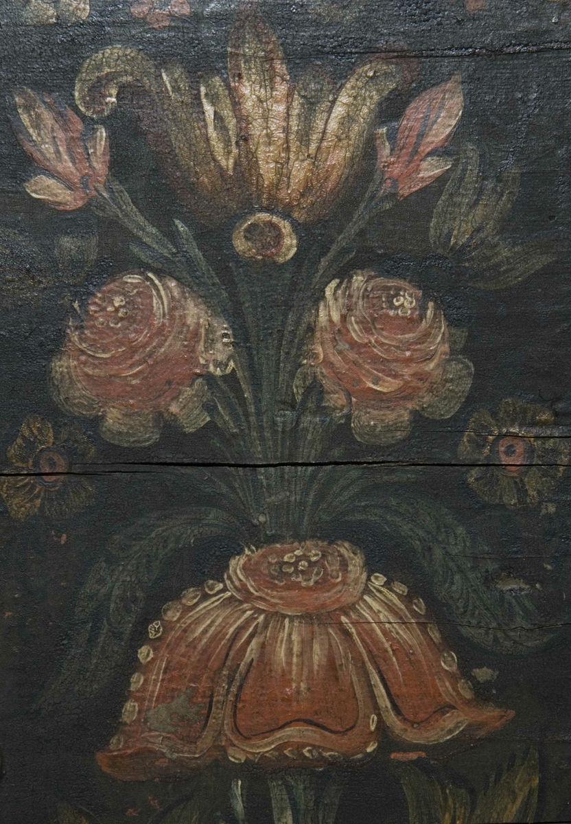 Kiste med buet lokk og heldekkende rosemaling, hvorav mye er senere tilføyelser eller restaureringer. Kulebena er også sekundære.