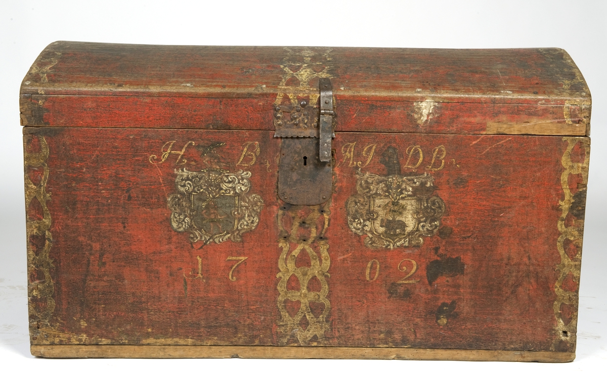 Kiste i eik med buet lokk, rødmalt og med to våpenskjold på fronten. På hjørner malt imitasjon av beslag. Innvendig umalt.