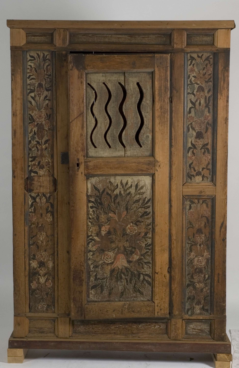 Melkeskap med en dør med fire gjennombrutte bølgende linjer og fire hyller invendig. Dekorert med blomstermotiver, rosemalt.
